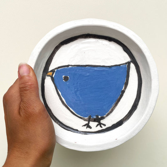 Handgemaakte witte keramische bordjes met een blauw vogeltje in volkskunststijl, set van 4