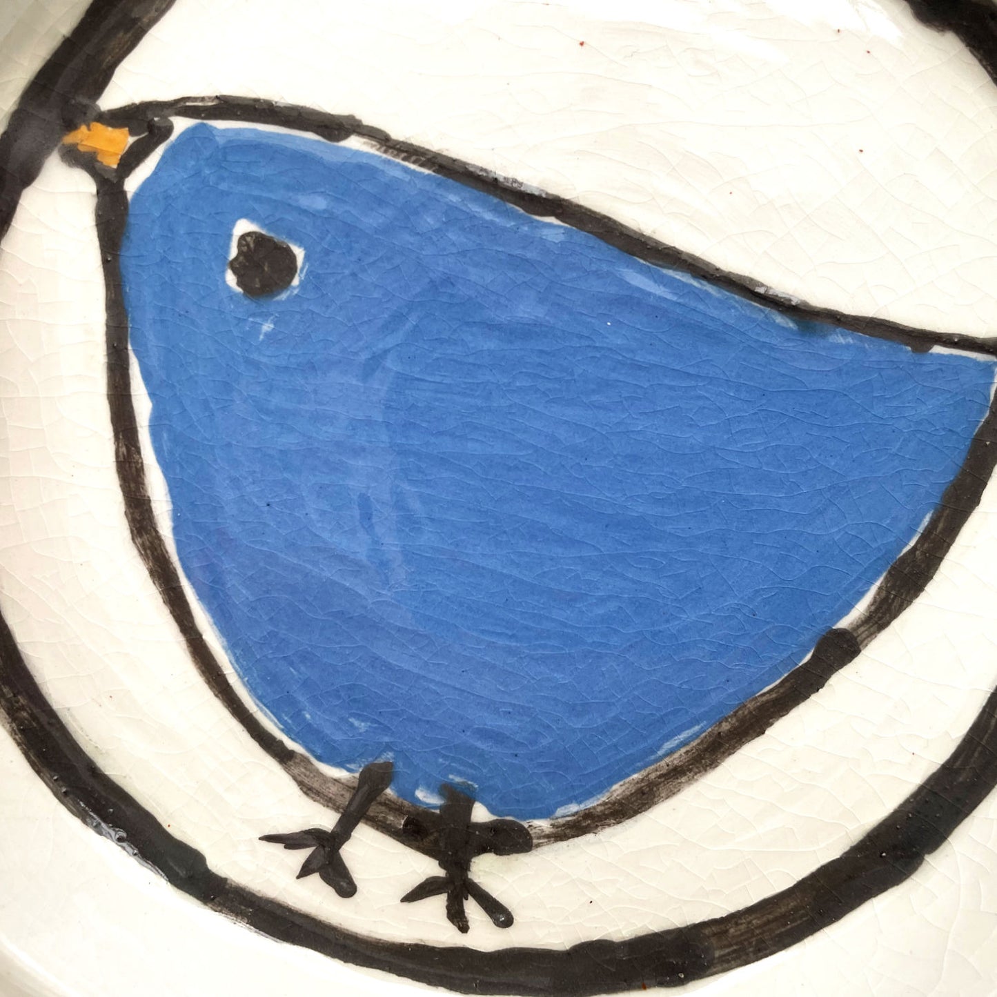 Handgemaakte witte keramische bordjes met een blauw vogeltje in volkskunststijl, set van 4