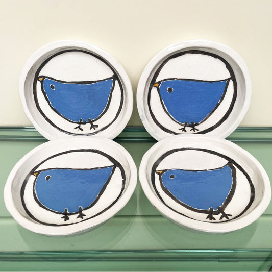 Handgemaakte witte keramische bordjes met een blauw vogeltje in volkskunststijl, set van 4